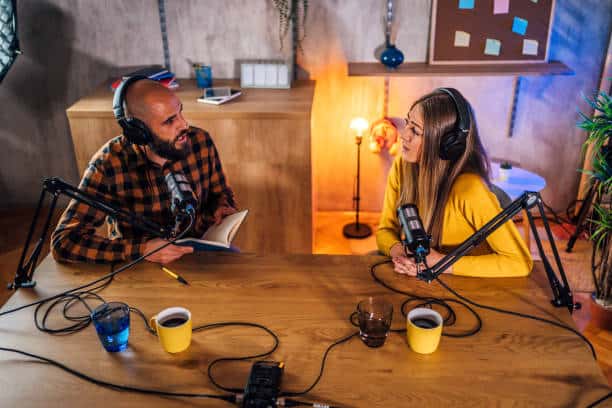 podcasters talking to microphones, recording podcast in studio
